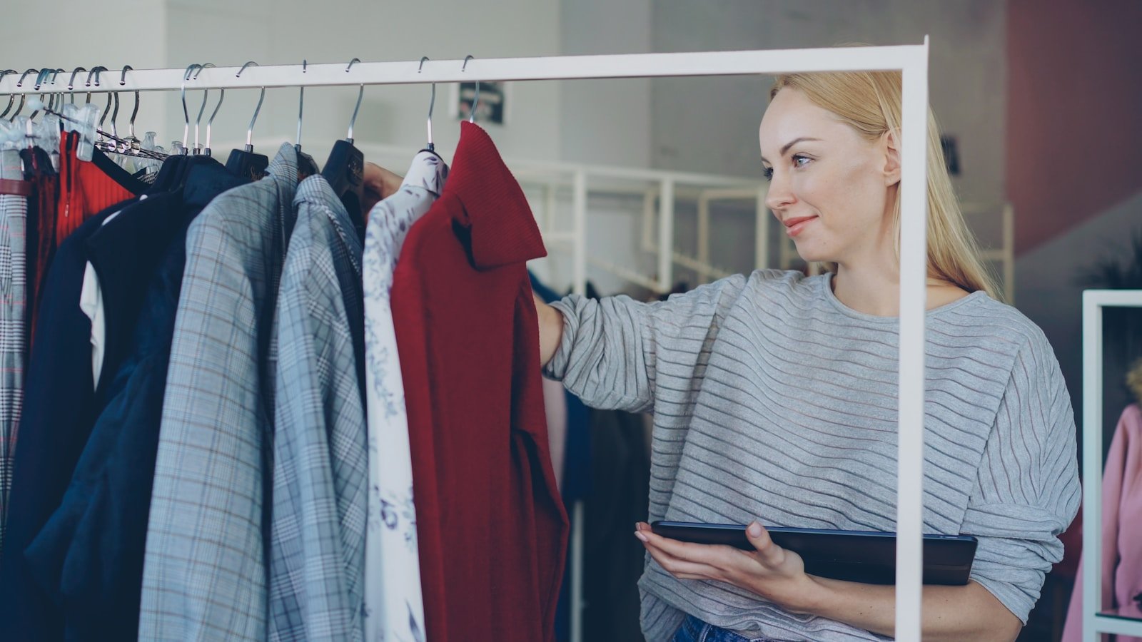 Woman looks at clothing on a rack.
